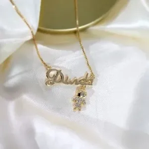 colar ouro escrita dinda menino pendurado