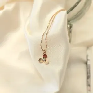 tornozeleira ouro com uma florzinha meio zirconia pendurada