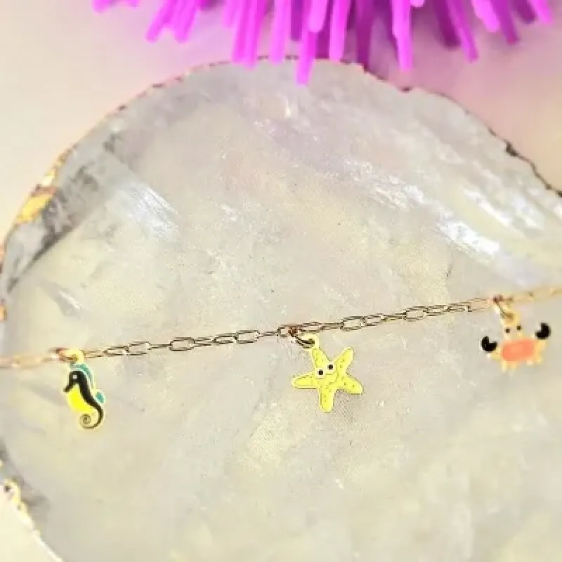 pulseira infantil ouro cavalo marinho + estrela do mar + siri
