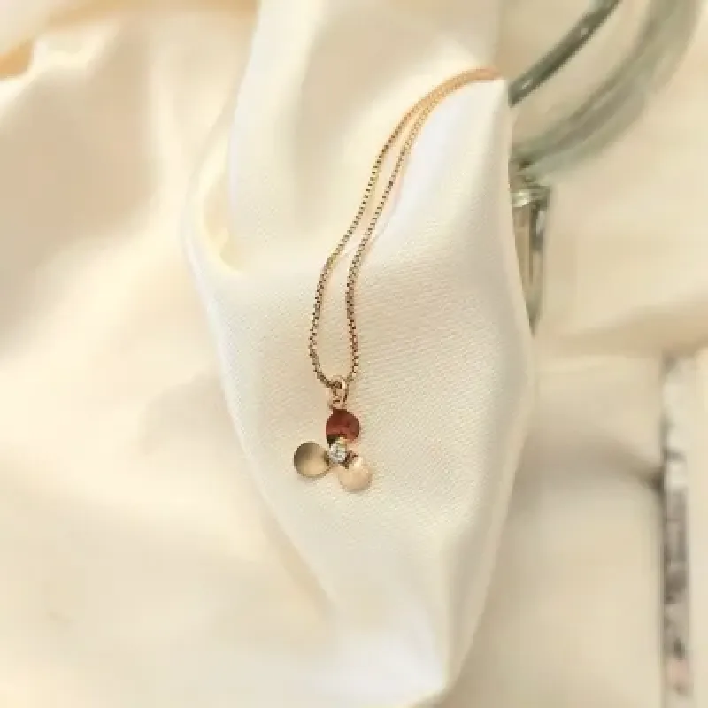 tornozeleira ouro com uma florzinha meio zirconia pendurada
