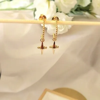 brinco ouro argola oval com bolinhas e uma cruz pendurada