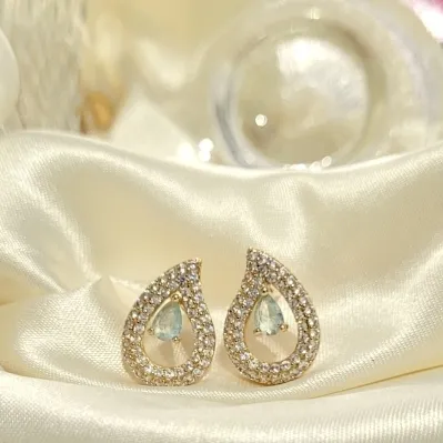 brinco ouro gota vazada cravejada com meio cristal azul claro