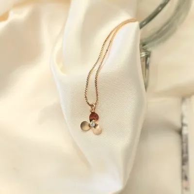 tornozeleira ouro com uma florzinha meio zirconia pendurada