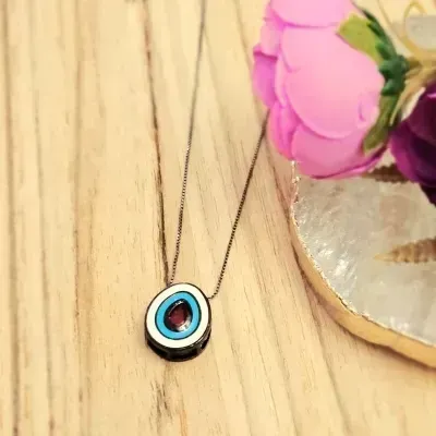 colar rodio negro gota esmaltada azul e branca com cristal vermelho no meio