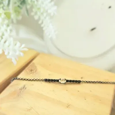 pulseira rodio negro fio com 10 zirconias negras com uma oval de cristal esverdeado no meio
