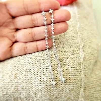 brinco rodio pendulo longo de estrelas de zirconias